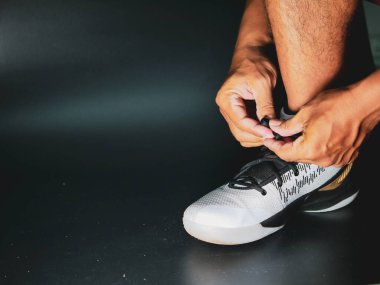 COVID-19 krizinden sonra antrenmana hazırlanmak için ayakkabı askısı bağlayan atletlerin yakın çekimleri.