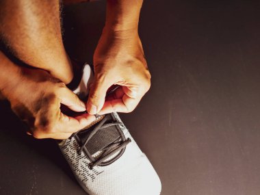 COVID-19 krizinden sonra antrenmana hazırlanmak için ayakkabı askısı bağlayan atletlerin yakın çekimleri.