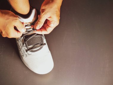 COVID-19 krizinden sonra antrenmana hazırlanmak için ayakkabı askısı bağlayan atletlerin yakın çekimleri.