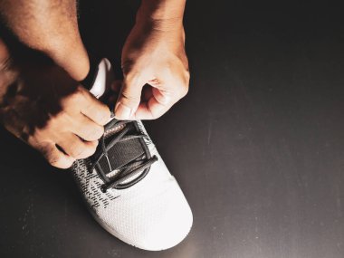 COVID-19 krizinden sonra antrenmana hazırlanmak için ayakkabı askısı bağlayan atletlerin yakın çekimleri.