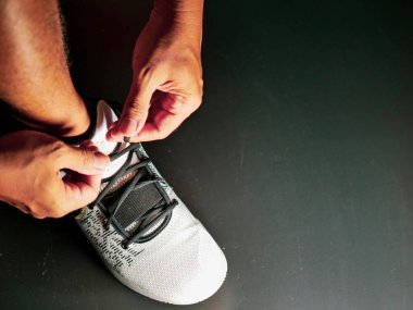 COVID-19 krizinden sonra antrenmana hazırlanmak için ayakkabı askısı bağlayan atletlerin yakın çekimleri.