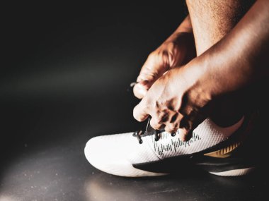 COVID-19 krizinden sonra antrenmana hazırlanmak için ayakkabı askısı bağlayan atletlerin yakın çekimleri.