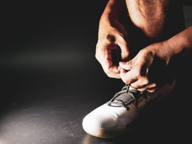 COVID-19 krizinden sonra antrenmana hazırlanmak için ayakkabı askısı bağlayan atletlerin yakın çekimleri.