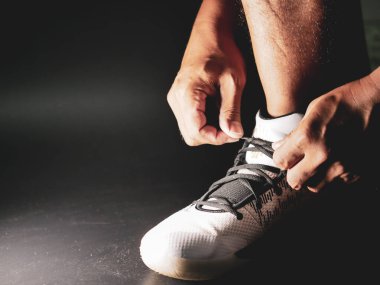 COVID-19 krizinden sonra antrenmana hazırlanmak için ayakkabı askısı bağlayan atletlerin yakın çekimleri.