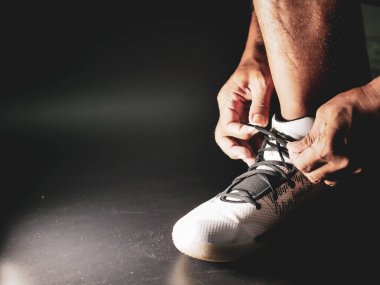 COVID-19 krizinden sonra antrenmana hazırlanmak için ayakkabı askısı bağlayan atletlerin yakın çekimleri.