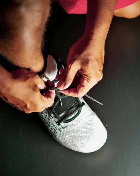 COVID-19 krizinden sonra antrenmana hazırlanmak için ayakkabı askısı bağlayan atletlerin yakın çekimleri.