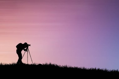 Renkli sırt çantalı bir fotoğrafçının silueti 