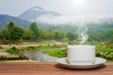 Dağlardaki ahşap masada kahve fincanı. 