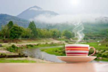 Dağlardaki ahşap masada kahve fincanı. 