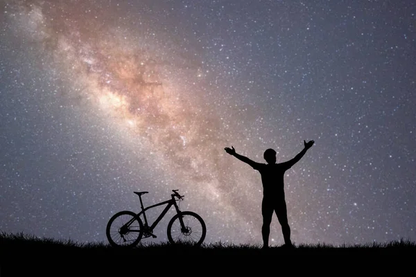 空に星が見える丘の上の男と自転車のシルエット — ストック写真