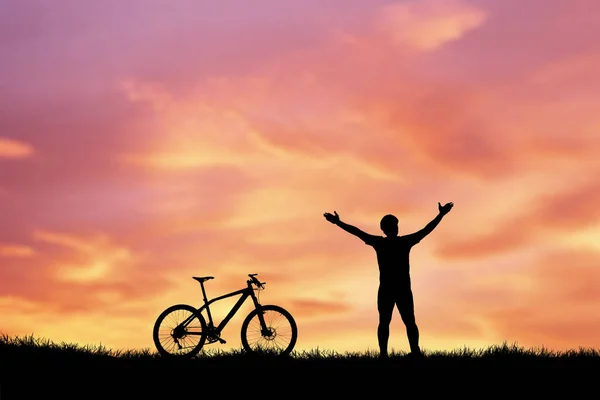 背景には夕焼け空の男と自転車のシルエット — ストック写真