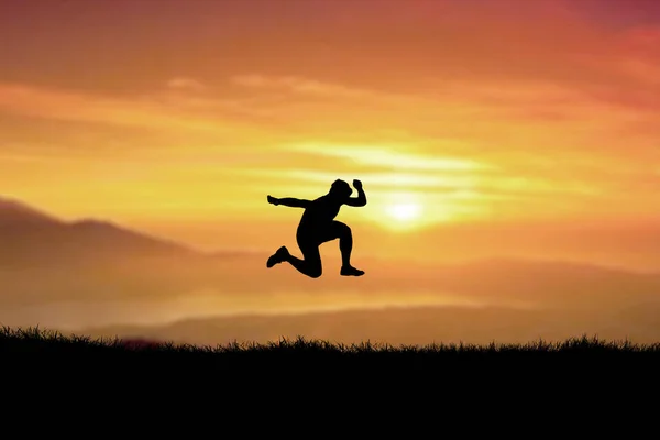 Silhouette Eines Mannes Der Auf Einem Hügel Springt Mit Sonnenuntergangshimmel — Stockfoto