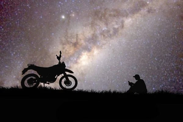 空に星が見える丘の上の男とバイクのシルエット — ストック写真