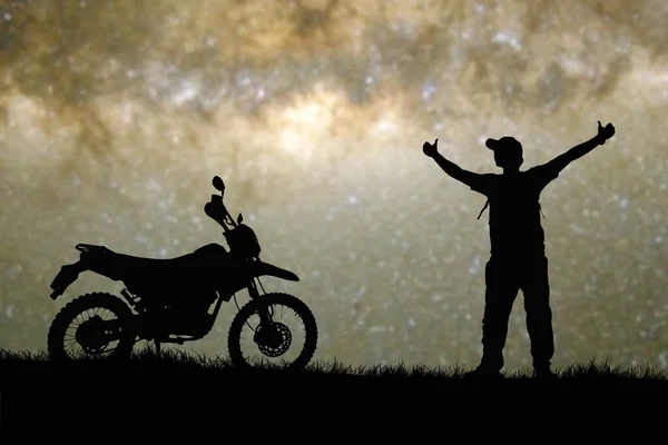 空に星が見える丘の上の男とバイクのシルエット — ストック写真