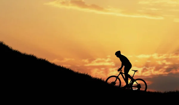 骑自行车戴头盔 背天落山的人的轮廓 — 图库照片