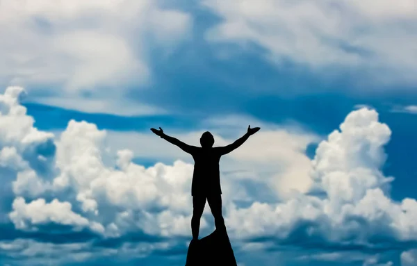 Silhouette Man Standing Rock Raised Hands Cloudy Sky Background — Stock Photo, Image