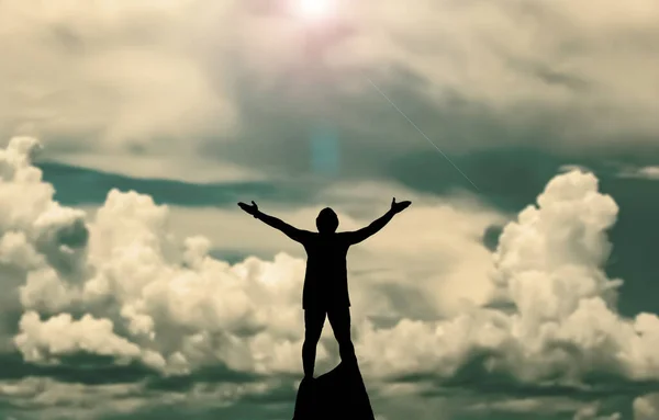 Silhouette Man Standing Rock Raised Hands Cloudy Sky Background — Stock Photo, Image