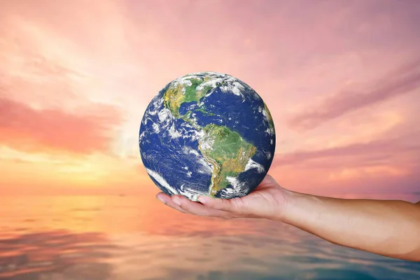 Man\'s hand holding Earth on a colored background with clipping path for use in conservation, global warming, pollution concepts. element of the picture is decorated by NASA