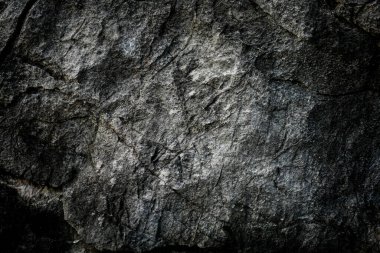 Arkaplan olarak soyut desenli koyu taş duvar 