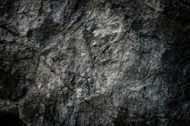 Arkaplan olarak soyut desenli koyu taş duvar 