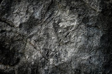 Arkaplan olarak soyut desenli koyu taş duvar 