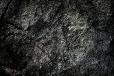 Arkaplan olarak soyut desenli koyu taş duvar 