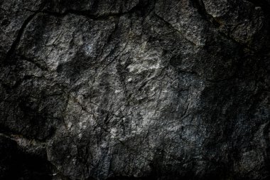 Arkaplan olarak soyut desenli koyu taş duvar 