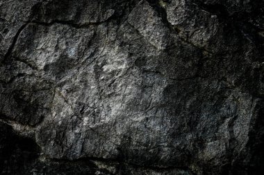 Arkaplan olarak soyut desenli koyu taş duvar 