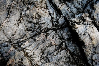 Arkaplan olarak soyut desenli koyu taş duvar 