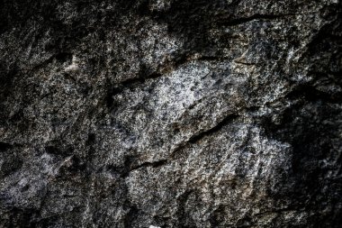 Arkaplan olarak soyut desenli koyu taş duvar 