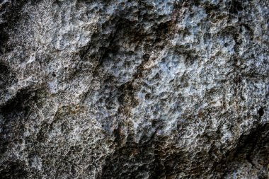 Arkaplan olarak soyut desenli koyu taş duvar 