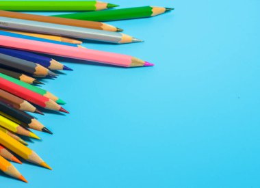 Mavi arkaplanda renkli kalemlerin görünümü