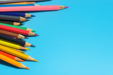 Mavi arkaplanda renkli kalemlerin görünümü