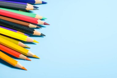 Mavi arkaplanda renkli kalemlerin görünümü