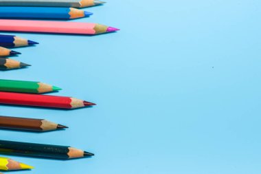 Mavi arkaplanda renkli kalemlerin görünümü