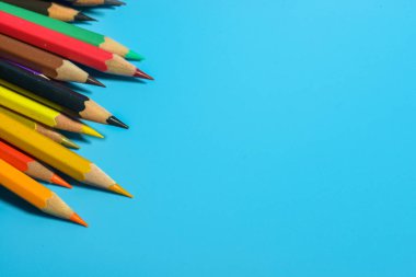 Mavi arkaplanda renkli kalemlerin görünümü