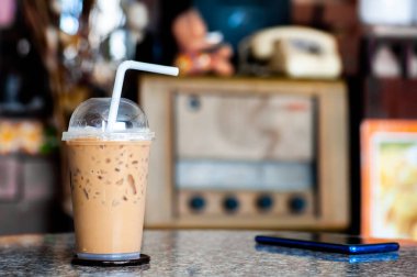 Tatilde vintage mağazasında bir masada buzlu kahve fincanı.