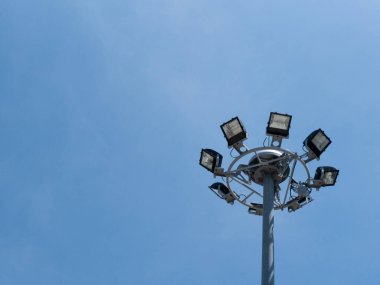 Mavi gökyüzünde projektörleri olan sokak lambası inşaatı