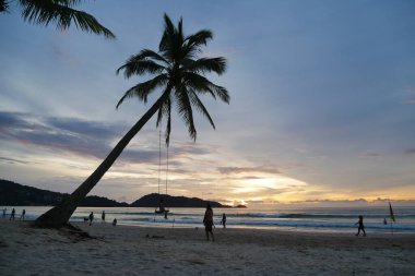 Gün batımında sahilde insan silueti