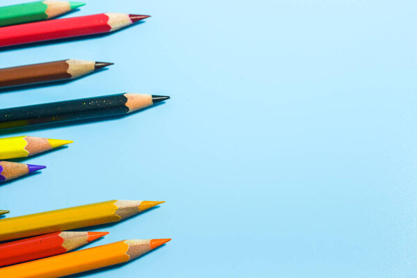 row of colorful pencils on blue background