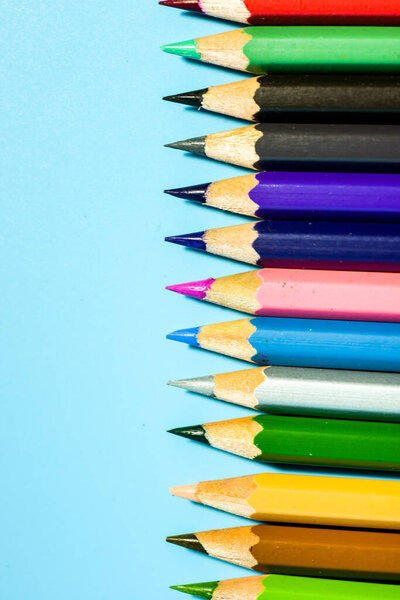 ряд красочных карандашей на синем фоне