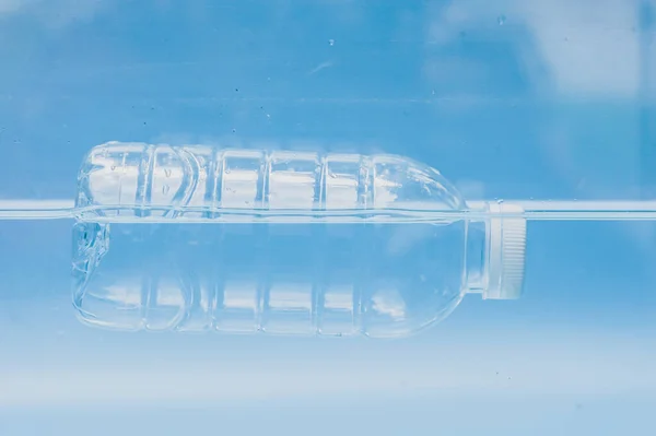プラスチック廃棄物は水の中に浮かぶ プラスチック製の水ボトルが水の中に浮かんでいます プラスチック廃棄物の概念 — ストック写真