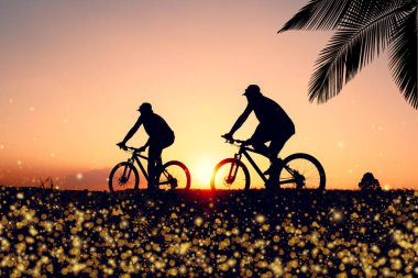 Günbatımının karanlık arka planında bisikletçi ve bisiklet siluetleri dolu