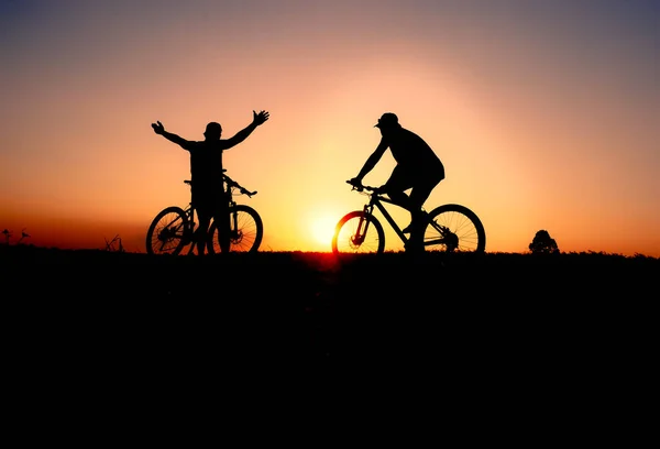 일몰의 어두운 배경에 자전거타기 자전거 실루엣 — 스톡 사진