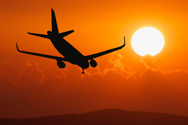 Силуэт истории пассажирского полета с туристами, приземляющимися в аэропорту. Самолёт садится на закате. пассажирский самолет приземляется на взлетно-посадочной полосе аэропорта рано утром на рассвете