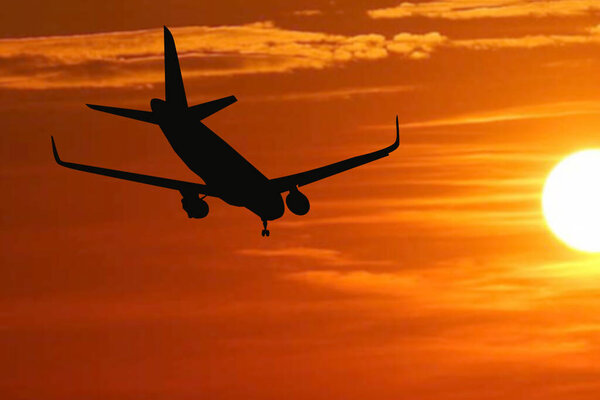 Silhouette of a passenger flight story with tourists landing at the airport. Airplane landing at sunset. passenger plane is landing in the airport runway at early morning at sunrise time