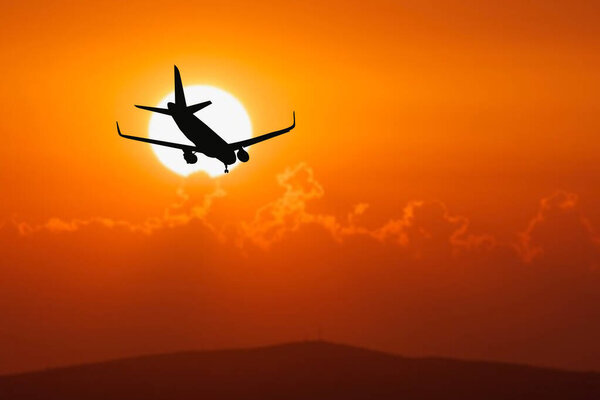 Silhouette of a passenger flight story with tourists landing at the airport. Airplane landing at sunset. passenger plane is landing in the airport runway at early morning at sunrise time