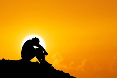 İşsiz bir adam, başı eğik, umutsuzca oturdu..