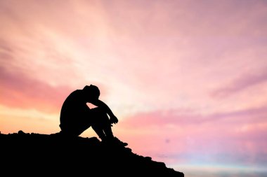 İşsiz bir adam, başı eğik, umutsuzca oturdu..