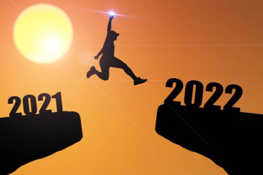 Mutlu yıllar 2022 Siluet resmi 2021 'den 2022' ye kadar güzel gökyüzünde mutlu bir adam.